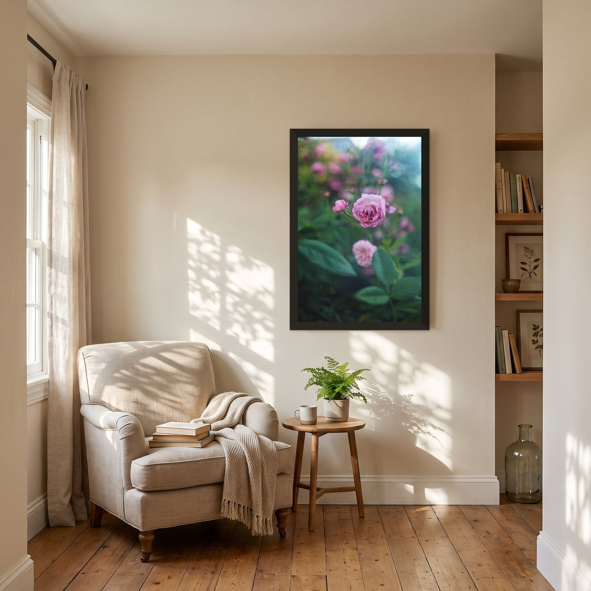 Caldwell Pink I, 24×36 inch print shown in a styled room mockup. Single pink rose rising among dark green leaves with blurred blossoms behind it. Frame shown for styling; print sold unframed.