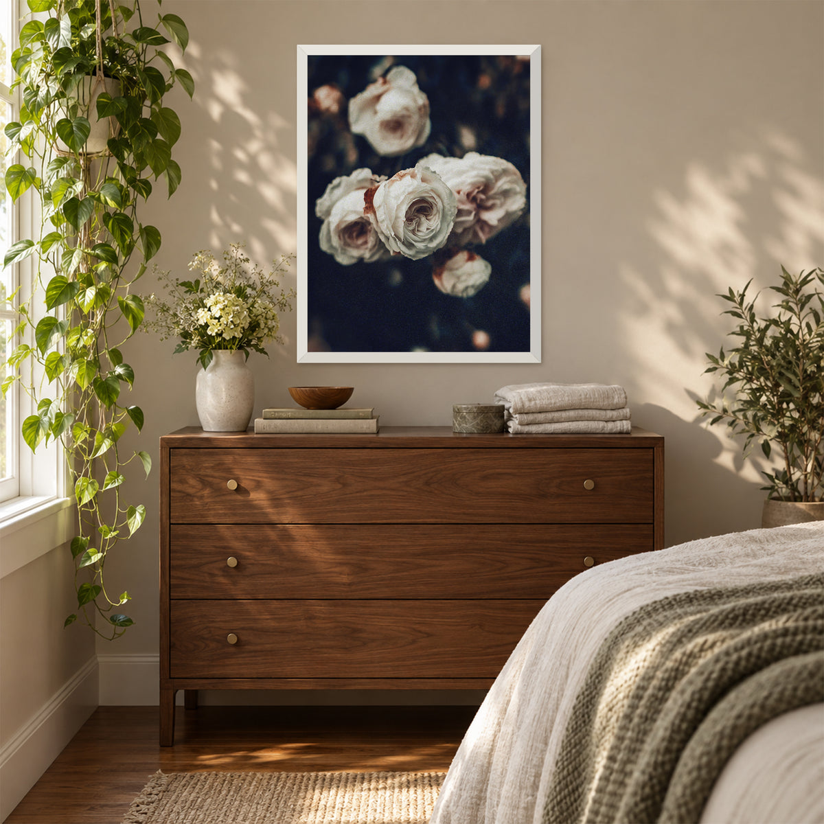 Cold Desdemona, 18×24 inch print shown in a styled room mockup. Cluster of ivory roses against a dark, softly blurred garden. Frame shown for styling; print sold unframed.