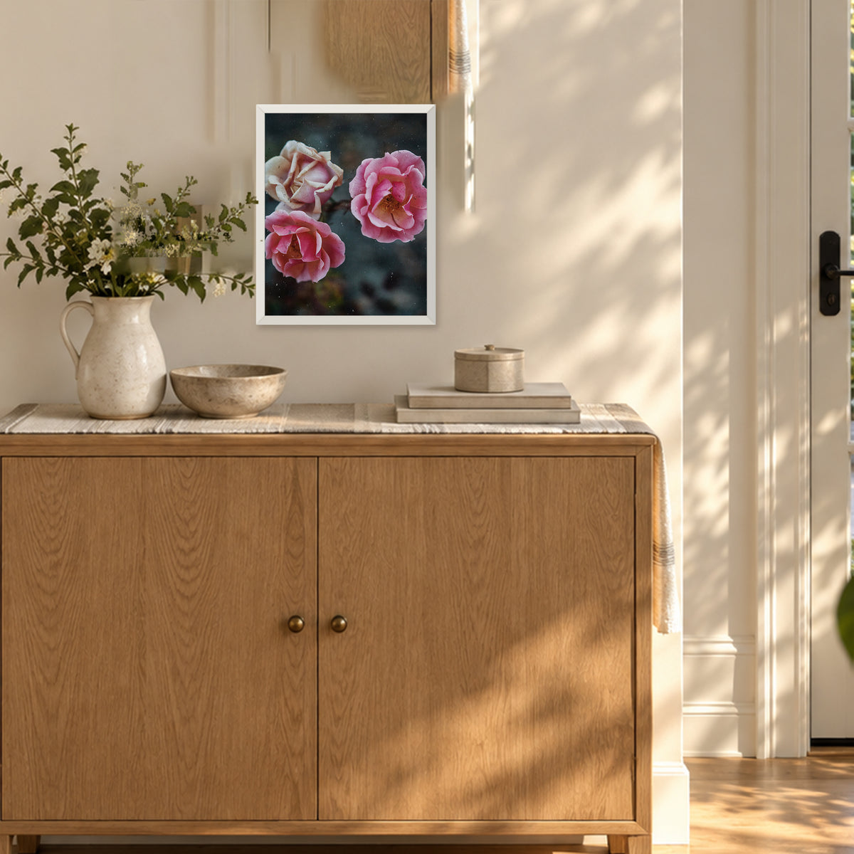 Duet Rose ︱ In Vibrant, 8×10 inch print shown in a styled room mockup. Two pink roses blooming beside a pale cream rose against a dark green background. Frame shown for styling; print sold unframed.